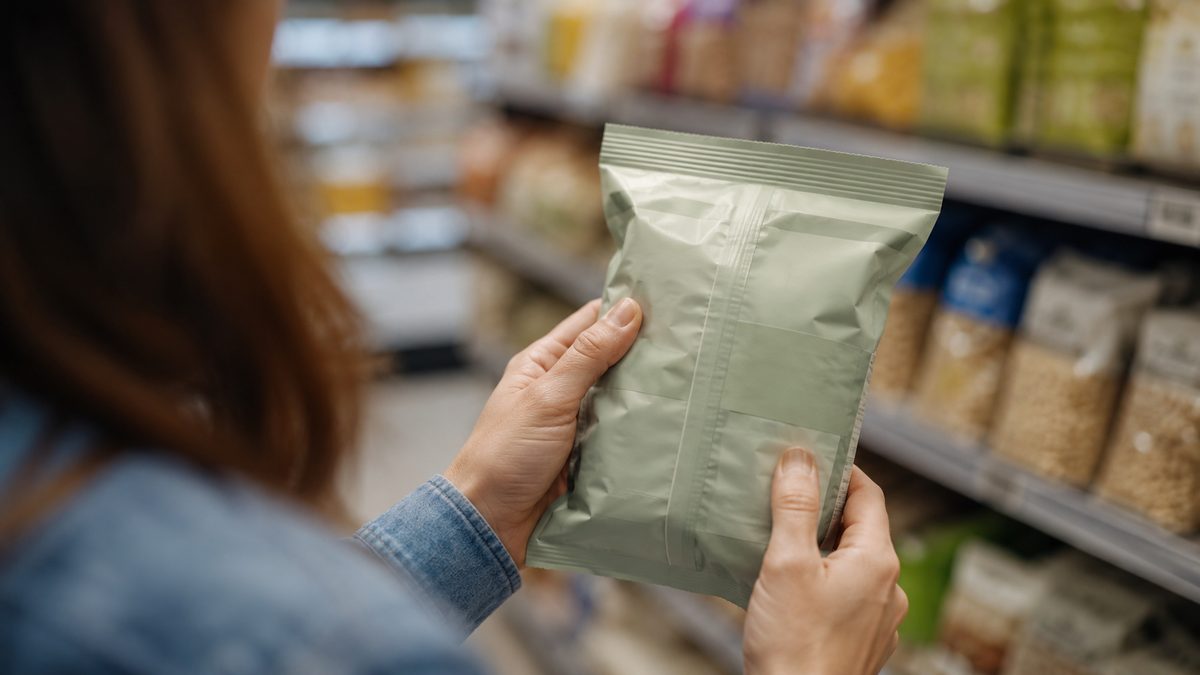 Shopper reading the nutrition label on a product in the supermarket